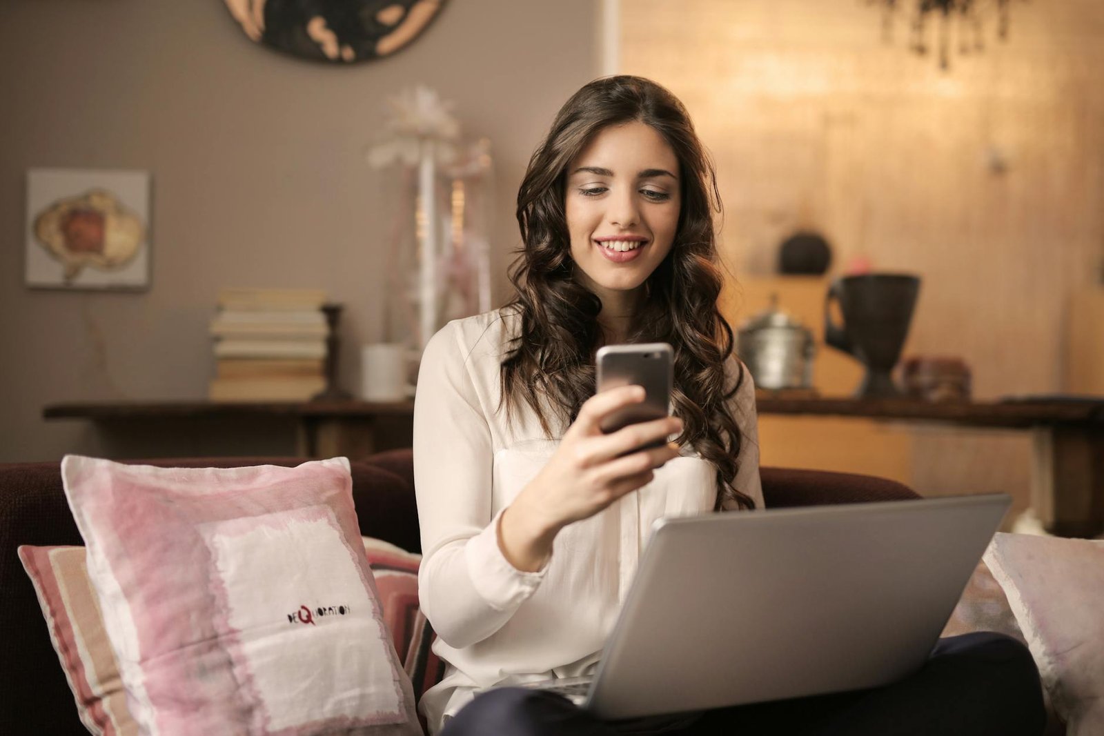 https://www.pexels.com/photo/woman-sitting-on-sofa-while-looking-at-phone-with-laptop-on-lap-920382/