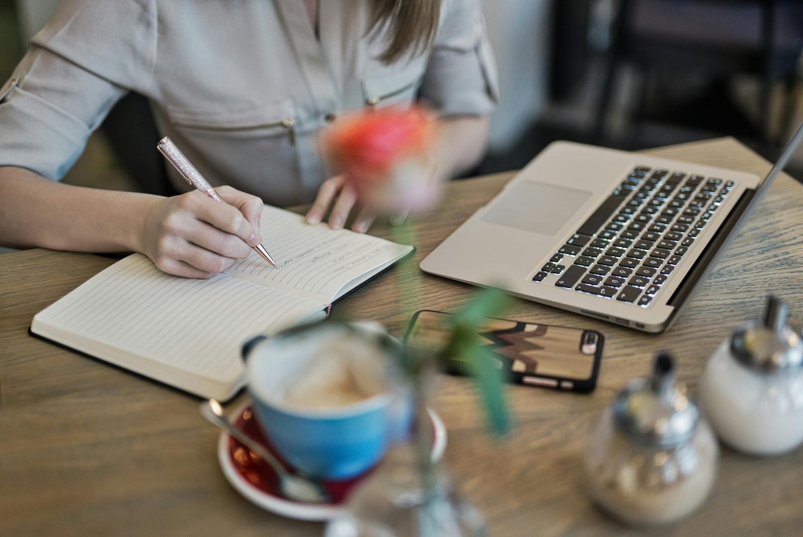 https://www.pexels.com/photo/person-writing-on-a-notebook-beside-macbook-1766604/